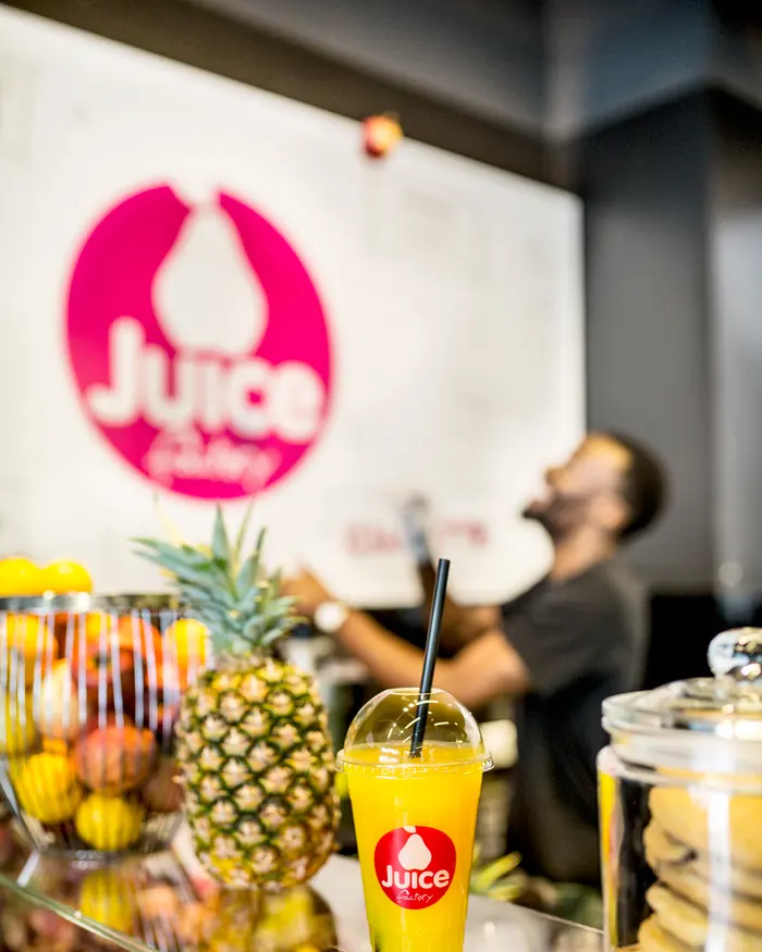 A juicer pressing fresh juice behind the counter
