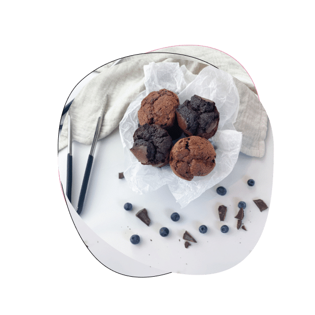 Schokoladenmuffins mit Heidelbeeren auf weißem Tisch