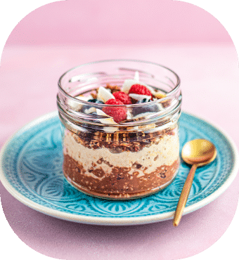 Haferflocken mit Beeren im Glas auf Teller