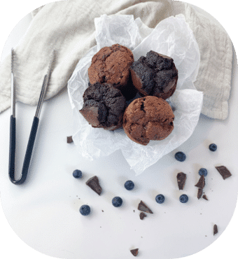 Schokoladen-Muffins mit Heidelbeeren auf weißem Hintergrund
