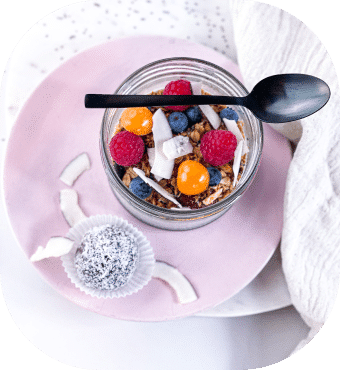 Gesundes Müsli mit Beeren und Kokosflocken im Glas.