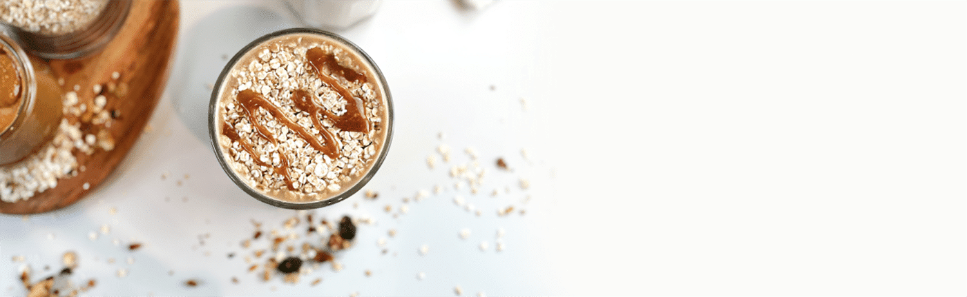 Haferflocken-Dessert mit Karamellsauce auf weißem Hintergrund.