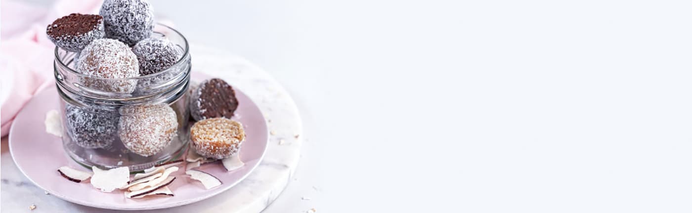 Kokosnuss-Pralinen im Glas auf rosa Teller